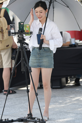 撑伞在直播的白衬衫主播